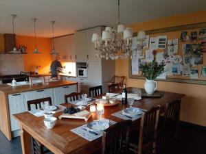 a kitchen with a wooden table with chairs and a dining room at Vakantiehuis Louiselotte in Alveringem