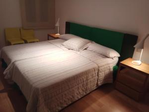 a bedroom with a large bed with a green headboard at APARTAMENTO MIRADOR DEL CADI in Puigcerdà