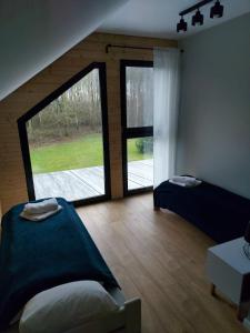 Habitación con 2 camas y ventana grande. en Dom przy lesie, en Wielgie