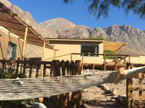 a house with mountains in the background at Cottages by the river in Rivadavia
