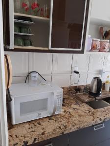 cocina con microondas y encimera en meu pequeno mundo, en Praia Grande 19 fotos más