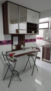 a kitchen with a table and a laptop on it at Apartamento em Guarapari in Guarapari