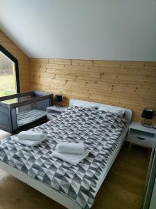 a large bed in a room with a wooden wall at Dom przy lesie in Wielgie