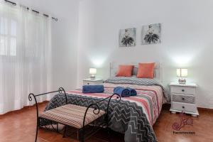 1 dormitorio con 1 cama y 1 silla en Casa Emblemática "Casa del Cuartel", en La Oliva
