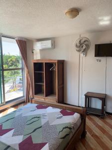 a bedroom with a bed and a window at Hotel Kemarios in Tonsupa