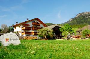 a building in the middle of a field in front of a yard at Singerhof in Castelrotto