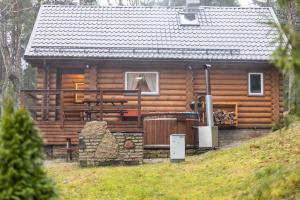 eine Blockhütte mit einer Veranda und einem Fenster in der Unterkunft Valkla Puhkekeskuse saunamaja in Kuusalu