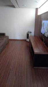 a living room with a couch and a flat screen tv at Apartamento em Guarapari in Guarapari