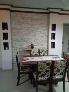 a dining room with a table and chairs and a brick wall at Apartamento em Guarapari in Guarapari