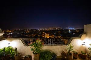 a view of a city at night from a balcony at Le cèdre d'argent in Fès
