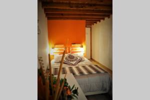 una camera da letto con un letto con una parete arancione di Casa D'Avó- Serra da Estrela a Sameiro