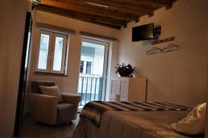 a bedroom with a bed and a chair and a television at Casa D'Avó- Serra da Estrela in Sameiro