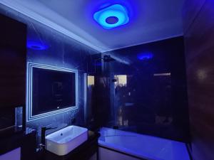 baño con lavabo blanco y luz azul en Legion Suite - Your perfect vacation !, en Niza