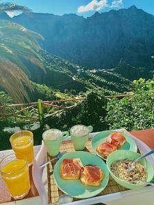 een tafel met borden en uitzicht op een berg bij Sweet Home Masca in Masca