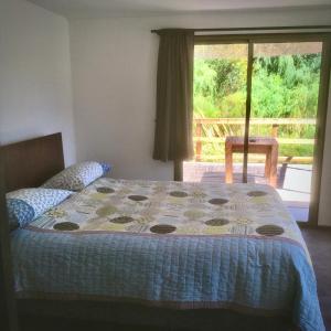 a bedroom with a bed with a quilt on it at Cottages by the river in Rivadavia
