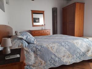 um quarto com uma cama, uma cómoda e um espelho em Quinta da Fonte da Poça - Chalé T1 no Gerês