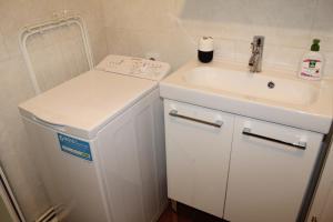 a small bathroom with a sink and a white refrigerator at Saclay - Green and premium flat close Paris - WIFI & NETFLIX in Saclay +19 photos