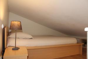 a bedroom with a bed with a lamp on a table at Saclay - Green and premium flat close Paris - WIFI & NETFLIX in Saclay