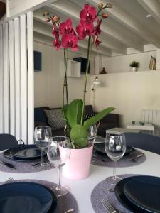 a table with glasses and a vase with a plant on it at Saclay - Green and premium flat close Paris - WIFI & NETFLIX in Saclay