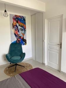 a bedroom with a chair and a painting on the wall at Eleven Studio Moderne et Chic au Diamant Martinique in Le Diamant