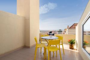 ヴィラ・ノヴァ・デ・ガイアにあるStunning Modern Flat w Terrace Miramar Gaiaの小さなバルコニー(テーブル、黄色い椅子付)