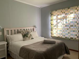 a bedroom with a bed with a large window at Chinta Cottage Hermanus in Hermanus +19 photos