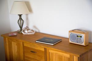 einen Tisch mit einer Uhr und einem Radio darauf in der Unterkunft Meadow Cottage in Bushmills