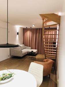 un soggiorno con scala e divano di Suites Le Porte-Bonheur a Bruges