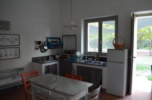 a kitchen with a sink and a refrigerator and a table at Masseria Montedoro in Ginosa Marina