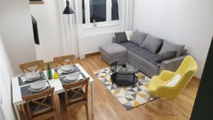 ein Wohnzimmer mit einer Couch und einem Tisch und Stühlen in der Unterkunft Apartman Mladenovic Divcibare in Divčibare