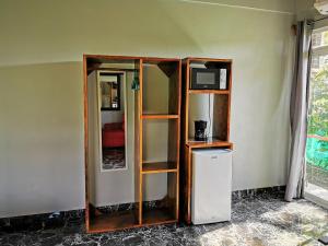 Cette chambre dispose d'une étagère, d'une télévision et d'un réfrigérateur. dans l'établissement Tuki Tuki Lodge, à Sámara