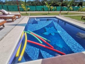 a swimming pool with colorful plastic toys in it at Tuki Tuki Lodge in Sámara