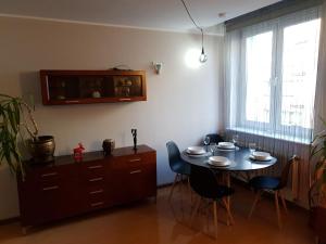 a dining room with a table and chairs and a window at Apartament komfortowy Levino in Lębork