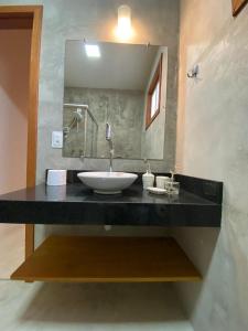 a bathroom with a sink and a mirror at Pousada Bahia-Nova Caraíva in Caraíva