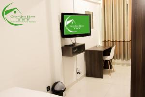 a room with a tv on a wall with a desk at Green Stay house in Maputo