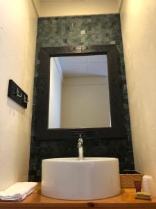 lavabo en el baño con un espejo grande encima. en Trailside Inn, en Killington