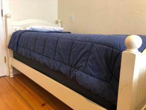 a bed with a blue blanket on top of it at Trailside Inn in Killington