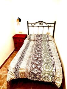 Una cama con una manta en un dormitorio en Casa en Busquistar, en Busquístar