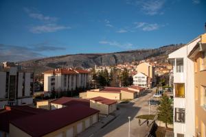 a city street with buildings and mountains in the background at Apartman Ante in Livno