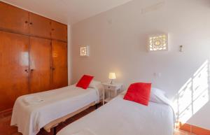 1 dormitorio con 2 camas y almohadas rojas en Tio Papel IV, en Albufeira