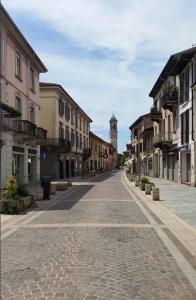 an empty street with a clock tower in the distance at BnBFuoriMilano in Rho