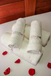 Duas toalhas em cima de uma banheira com rosas vermelhas em Pousada Bahia-Nova Caraíva em Caraíva