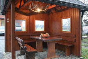 a wooden shed with a table and a bench at Apartma Vila Zigmund in Cerknica