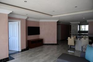 a living room with a couch and a tv on a wall at Apartment C307 at The Sails in Durban