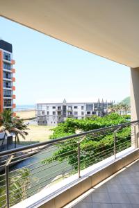 a balcony with a view of the beach and buildings at Apartment C307 at The Sails in Durban