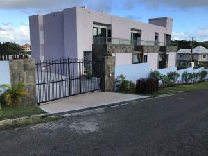 una casa bianca con un cancello su una strada di One Rodney Heights Condominiums a Gros Islet