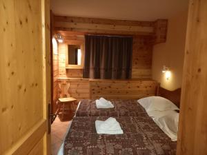 een slaapkamer met een bed met handdoeken erop bij La Voute apartments in La Grave