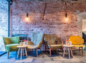 a group of chairs and tables in front of a brick wall at Mr. Jordaan in Amsterdam