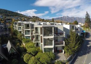 - une vue aérienne sur un grand bâtiment blanc avec des arbres dans l'établissement Scenic Suites Queenstown, à Queenstown