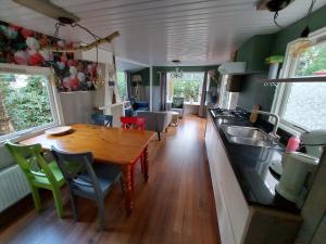 comedor y cocina de una cabaña con mesa de madera en Chalet Hoenderloo Beuk en Hoenderloo